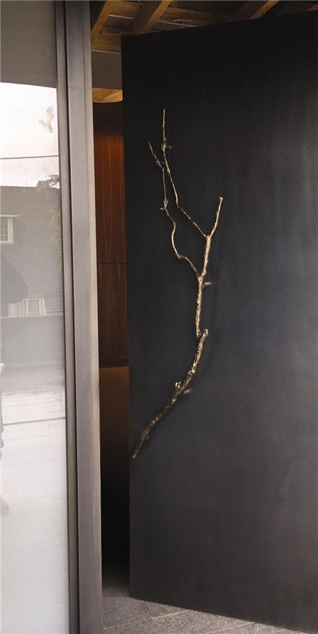 Minimalist Entryway with Black Wall and Natural Branch Art