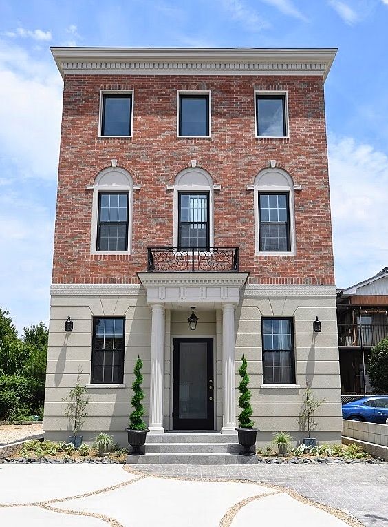 Three-Story Brick and Stucco Home with Classic Columns and Symmetrical Windows