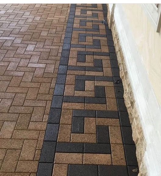 Modern Brick Driveway With Geometric Border Pattern and Stone Wall